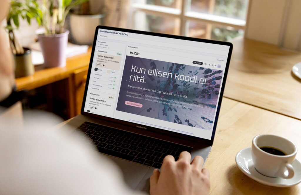 Henkilö käyttää kannettavaa tietokonetta, jonka näytöllä on auki kontrastitarkistin Hurjan verkkosivustoa auditoiden.